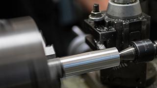 A block of metal is being turned into a cone at a lathe.